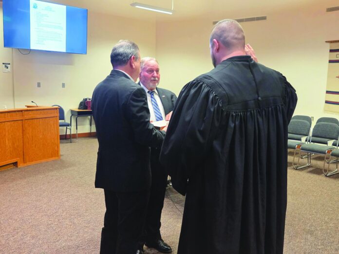 New Española City Police Chief Jack Jones (facing camera) gets sworn in May 26 by Española Municipal Judge Joseph W. Madrid, while District 2 City Councilor Stephen Salazar holds the Bible.