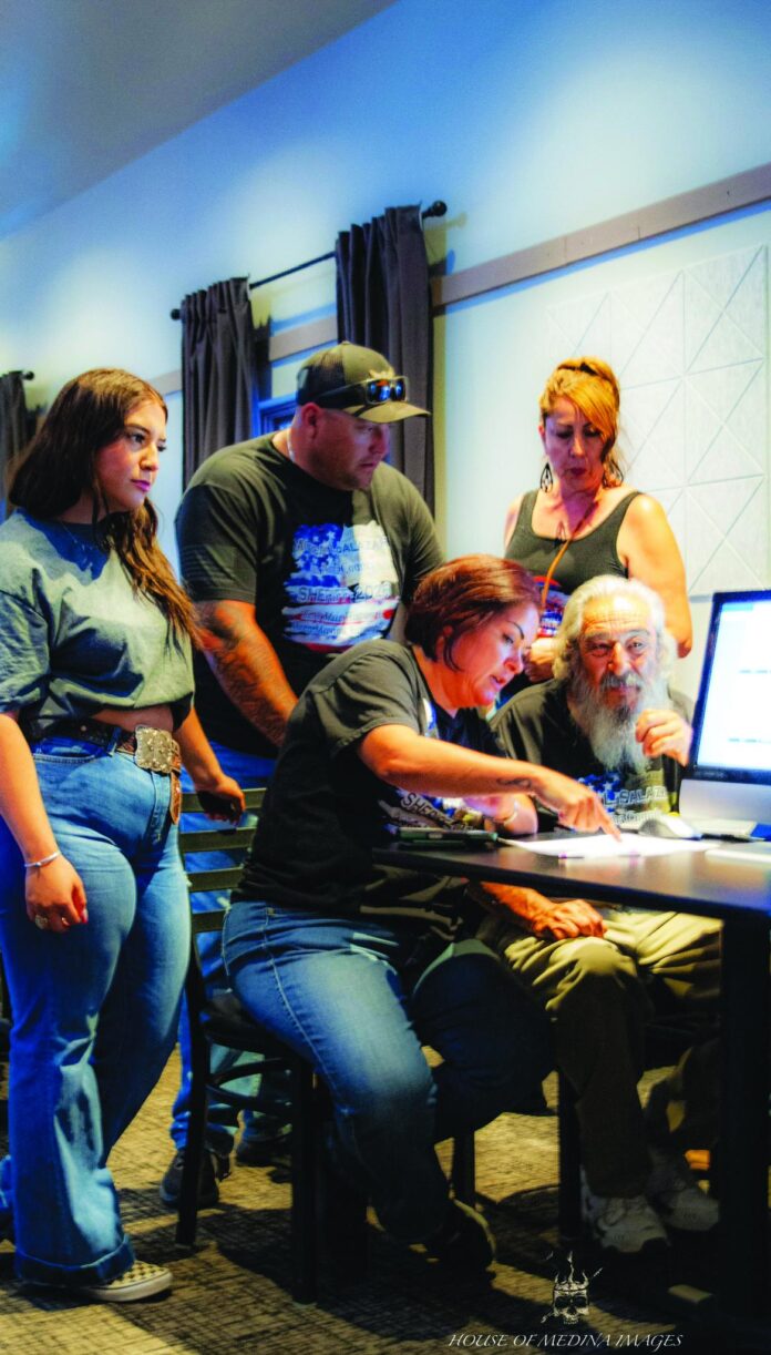 Sheriff’s candidate Monica Salazar goes over election results with supporter Ross Varela (seated), as Jamie Coriz (standing, left), Jack Casias and an unidentified supporter look on Tuesday night during Salazar’s watch party at Apple Valley Kitchen.