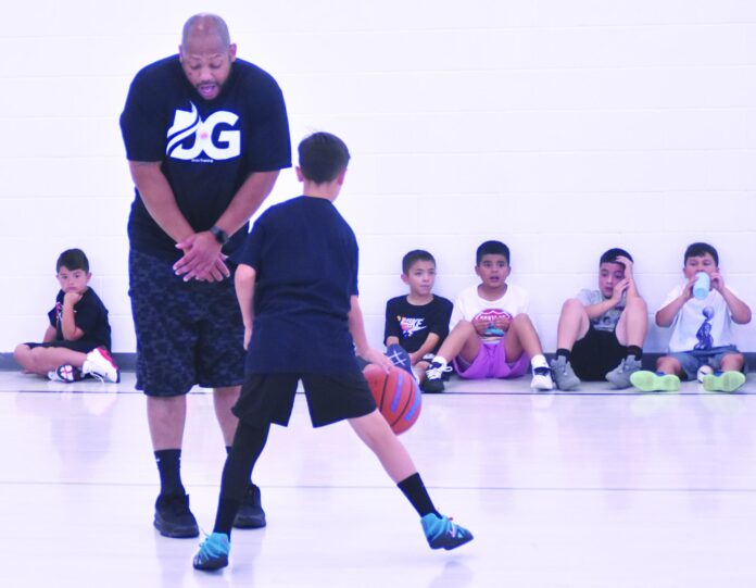Mesa Vista sixth-grader Alex Trujillo uses former New Mexico Lobos star Dairese Gary as a screen during live play Monday at a one-day camp at Mesa Vista High School.