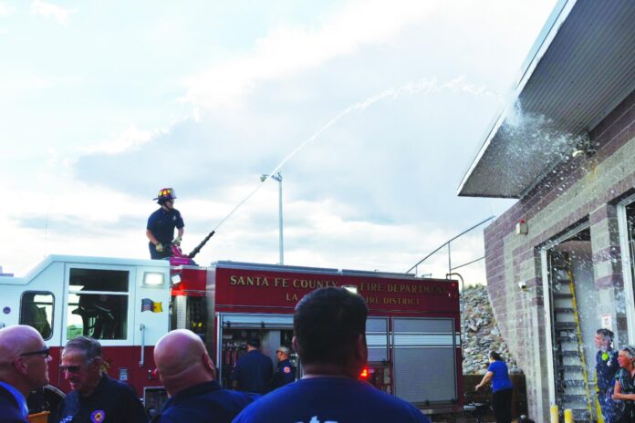 Fire Lt. Manuel Gallegos sprays La Puebla 52 during the wet down ceremony Thursday (6/18) at the La Puebla Fire Station.