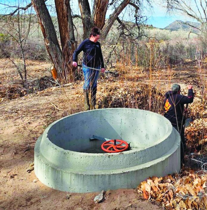 Helen helps her husband Enrico clean a siphon in the Acequia de Los Gallegos in Ojo Caliente.