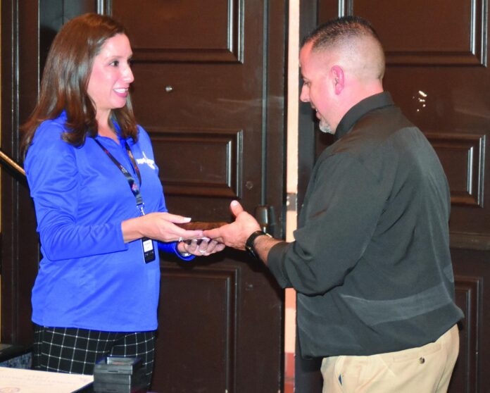 Mesa Vista girls basketball coach Jesse Boies (right) receives the New Mexico High School Coaches Association girls basketball coach of the year award Friday from Pojoaque Valley alum Jackie Martinez, New Mexico Activities Association assistant director of sports, at an awards ceremony in Albuquerque.