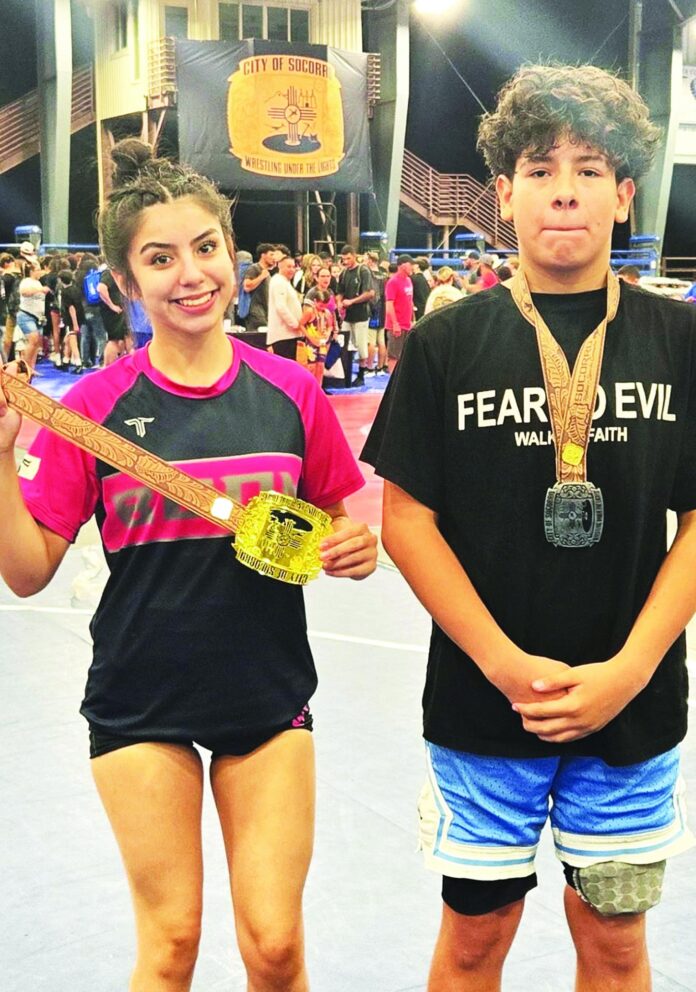 Jazlynn Maestas (left) of Española’s Boom Wrestling, shows off the gold medal she earned at the recent Socorro Wrestling Under The Lights meet, where Juanito Lopez (right), who is going to be a seventh grader at Carlos F. Vigil Middle School, took second in the 12 and under age group.