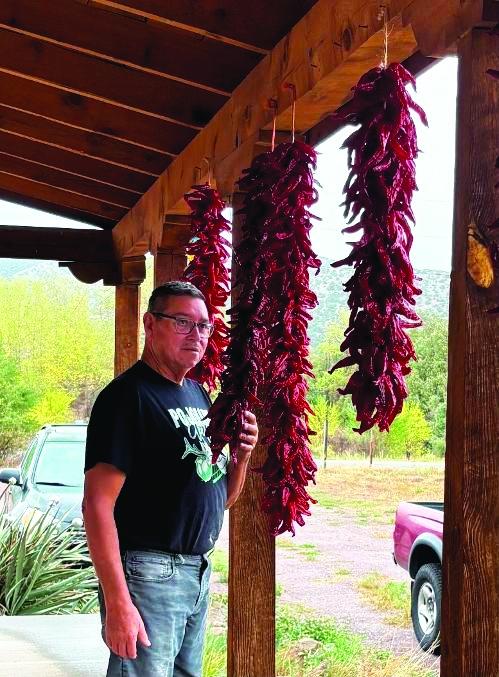 Eddie takes time to inhale and enjoy the lightly sweet, fruity, hint of picante of his drying ristras of landrace red chile.
