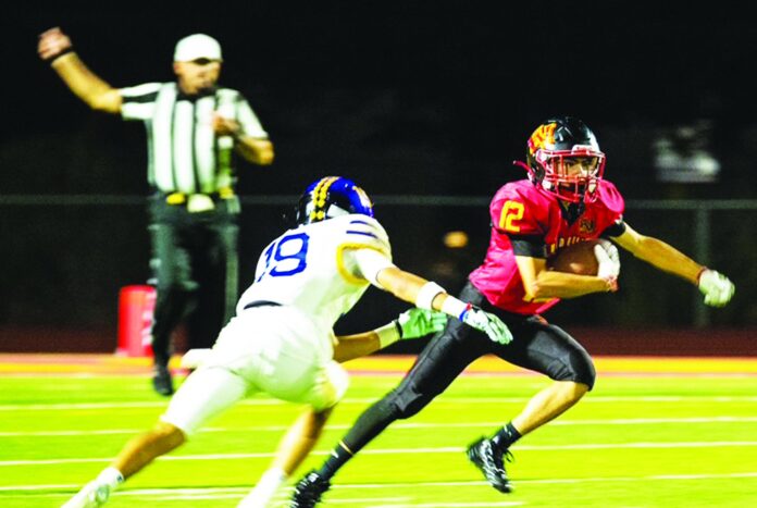 Española Valley quarterback Cody Trujillo looks to elude Bloomfield defenders Thursday. Trujillo threw for two touchdowns, but the Sundevils lost 63-16 to the two-defending state champion Bobcats.